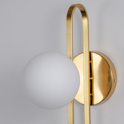 Minimal wall light with gold curved arm and white glass globe on neutral background modern elegant lighting for home decor.