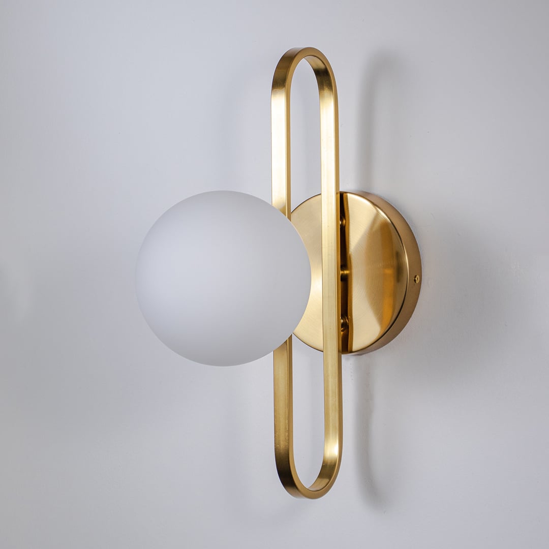 Wall lamp with frosted white glass globe and gold metal frame designed for stylish modern bedroom living room and hallway walls.