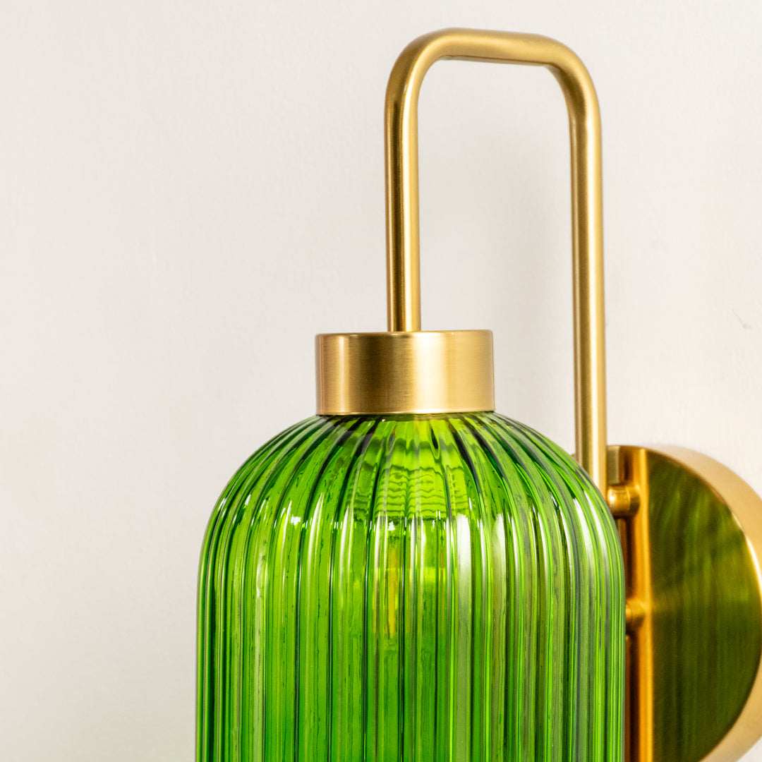 Closeup of gold metal wall light with green ribbed glass shade showcasing detailed texture and premium finish for modern decor styling.