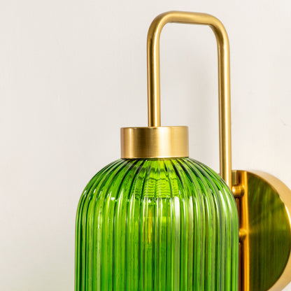 Closeup of gold metal wall light with green ribbed glass shade showcasing detailed texture and premium finish for modern decor styling.