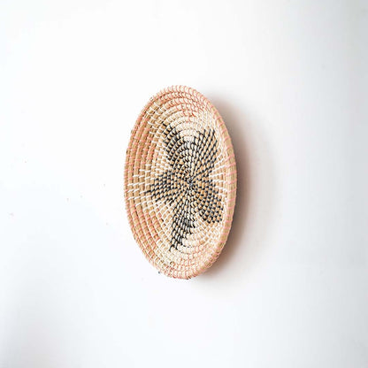 Side view of handwoven wall basket decor made of rustic natural fiber with boho star design for wall styling.