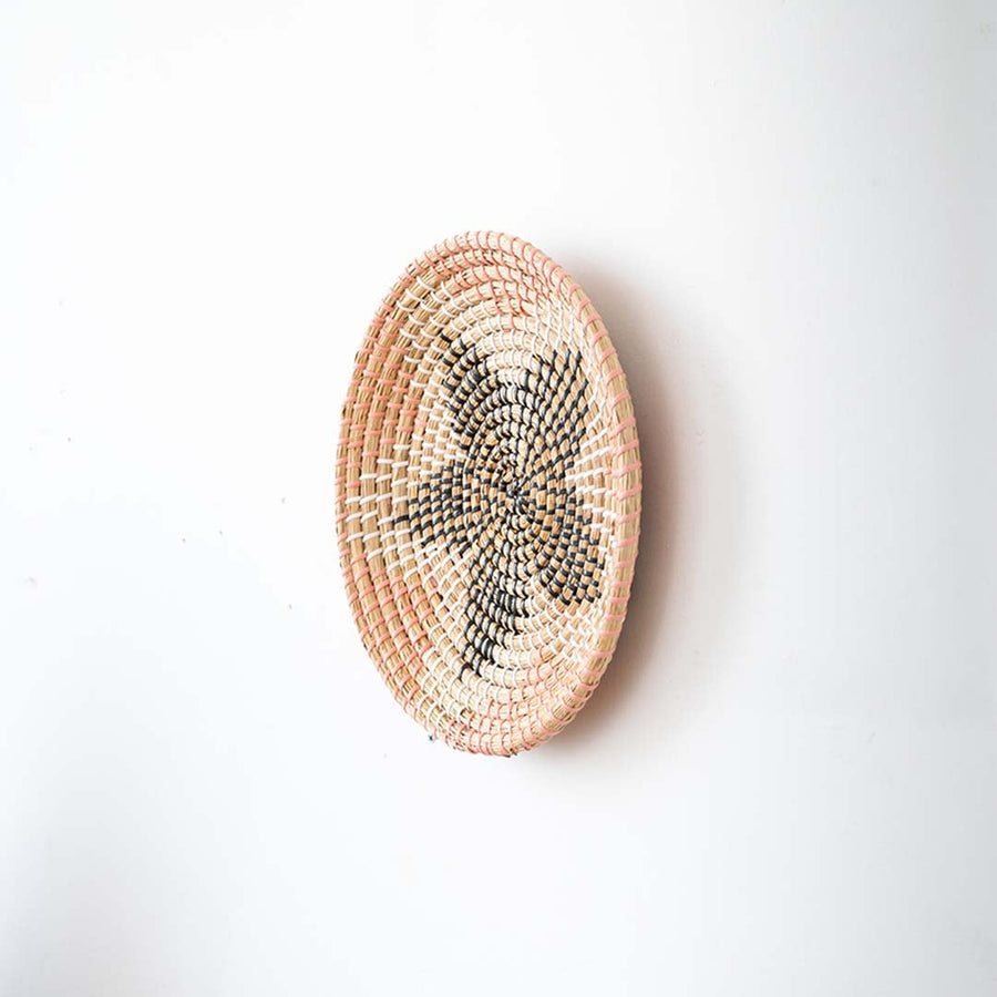 Side view of handwoven wall basket decor made of rustic natural fiber with boho star design for wall styling.