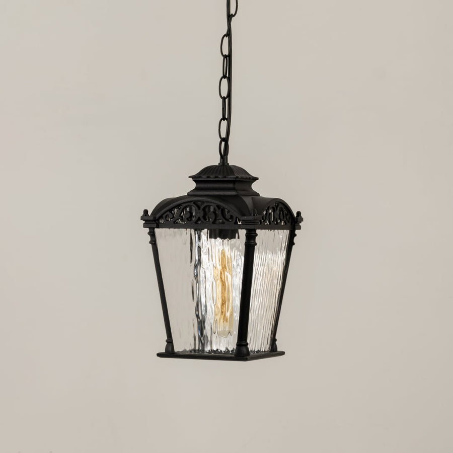 Black outdoor hanging lantern with the light off displayed on a white background showing its ornate top design clear textured glass panels and classic lantern shape.