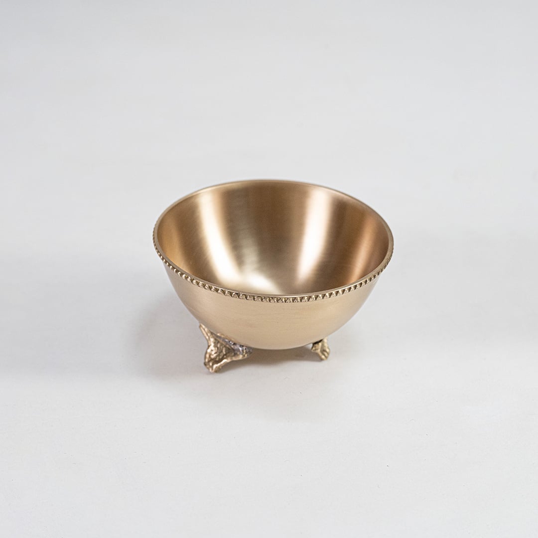 Single brass snack bowl with ornate footed base shown on a white background showcasing the smooth finish and detailed edging of the metal craftsmanship.