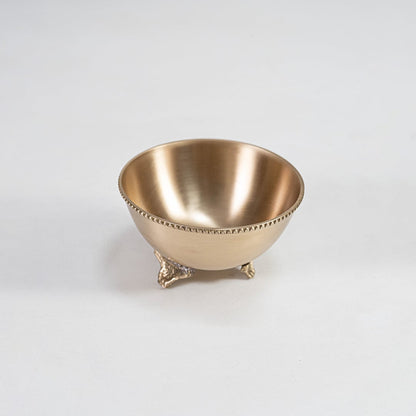 Single brass snack bowl with ornate footed base shown on a white background showcasing the smooth finish and detailed edging of the metal craftsmanship.