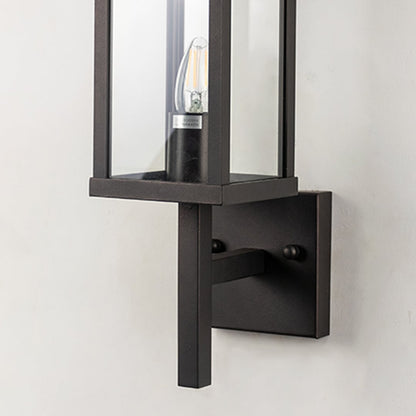 Closeup of outdoor wall light with black rectangular frame and glass shade designed for stylish exterior lighting.