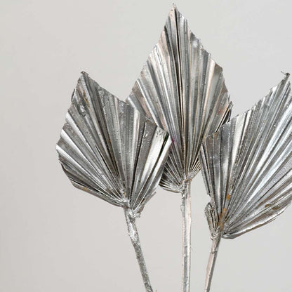 Closeup of silver metallic palm leaf stems with reflective finish adding elegant texture and modern luxury decor appeal.