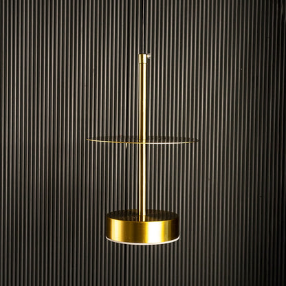 Halo brass pendant light turned on showing minimal ring-shaped brass design against white background.