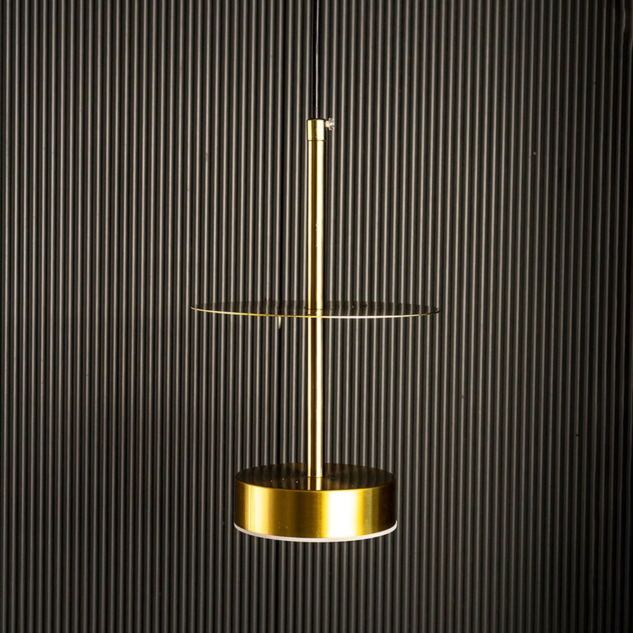 Halo brass pendant light turned on showing minimal ring-shaped brass design against white background.
