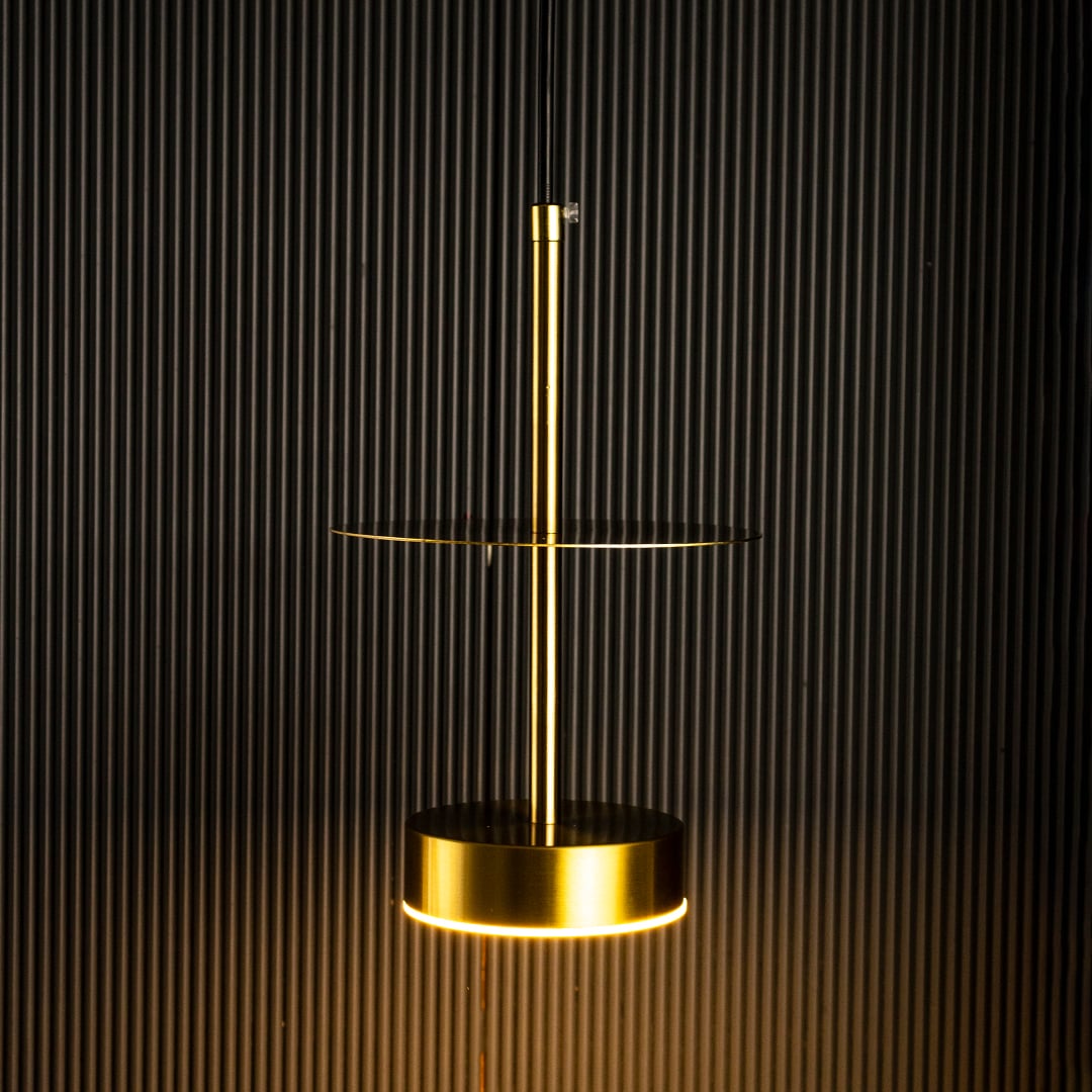 Closeup of halo brass pendant light turned off showing fine brass texture and circular pendant detailing.