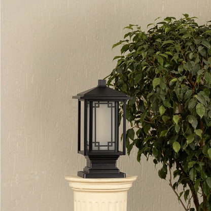 Black outdoor gate light styled beside green plants for elegant modern exterior decor ambiance.