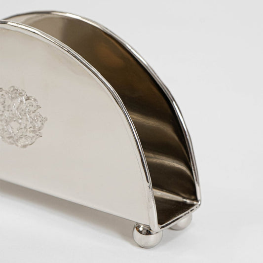 Main product image of half-moon shaped brass napkin holder with floral engraving and clean minimal design.