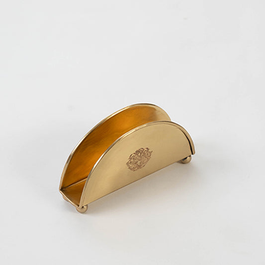Contemporary metal napkin holder in gold finish for dining table or kitchen decor accessory placement white background.