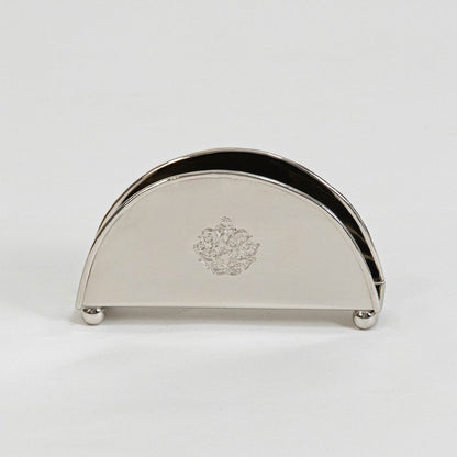 Half-round brass napkin holder with floral crest placed on white background showcasing finish and elegant shape.