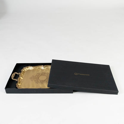 Antique brass floral tray partially packed in a premium black gift box with gold branding on a white background.