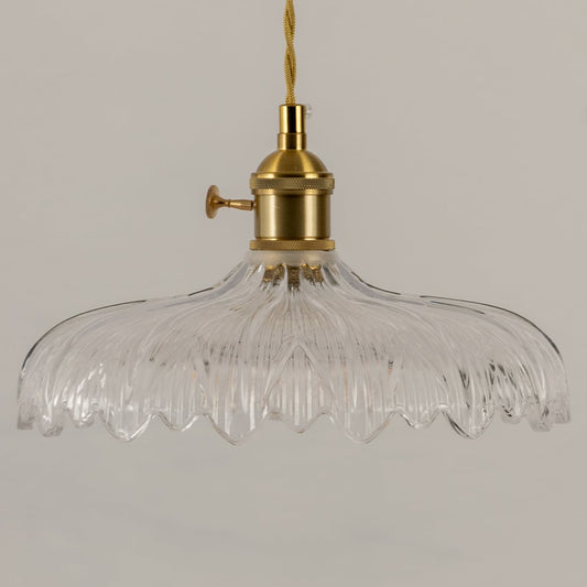 Clear textured glass pendant light with gold metal fixture illuminated to showcase elegant decorative ceiling lighting.