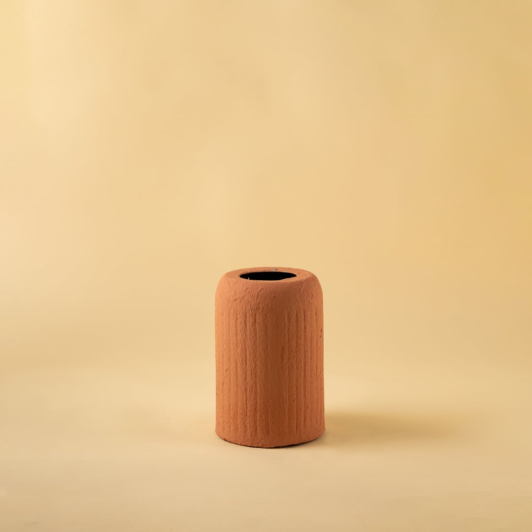 Terracotta ribbed ceramic vase displayed on a clean white background highlighting its natural warm tone and modern design.