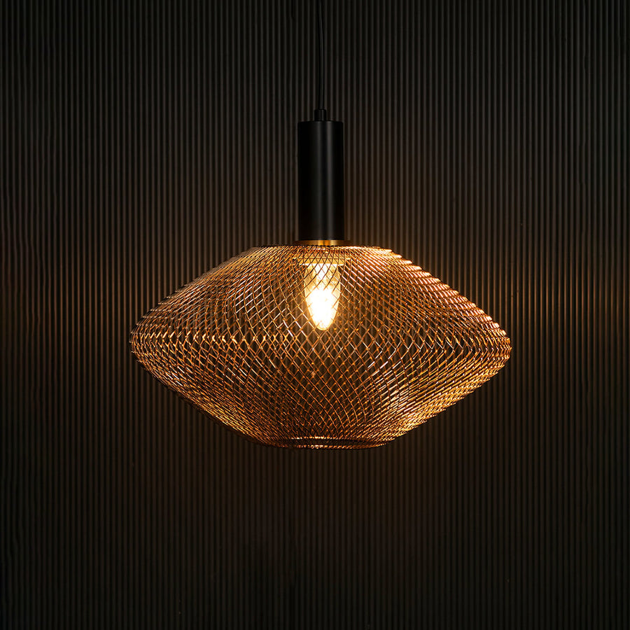 Gold metal mesh pendant light illuminated with warm glow creating cozy ambience.