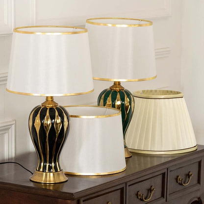 White shade beige spindle table lamp on wooden sideboard with light off for warm traditional living room décor.