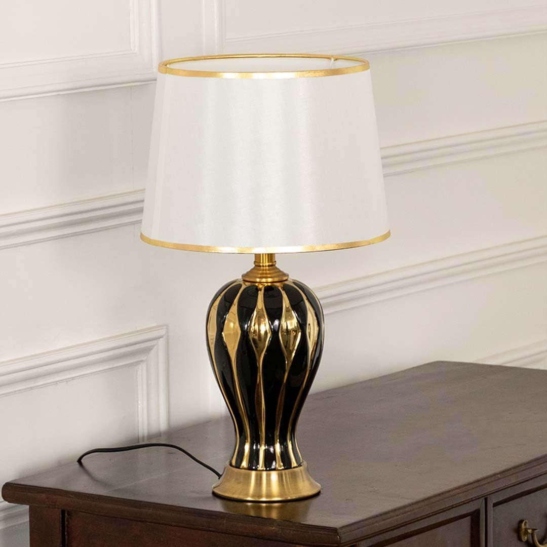 White shade gold decorative table lamp on wooden sideboard with light off for classic traditional home décor.