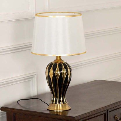 White shade gold decorative table lamp on wooden sideboard with light off for classic traditional home décor.