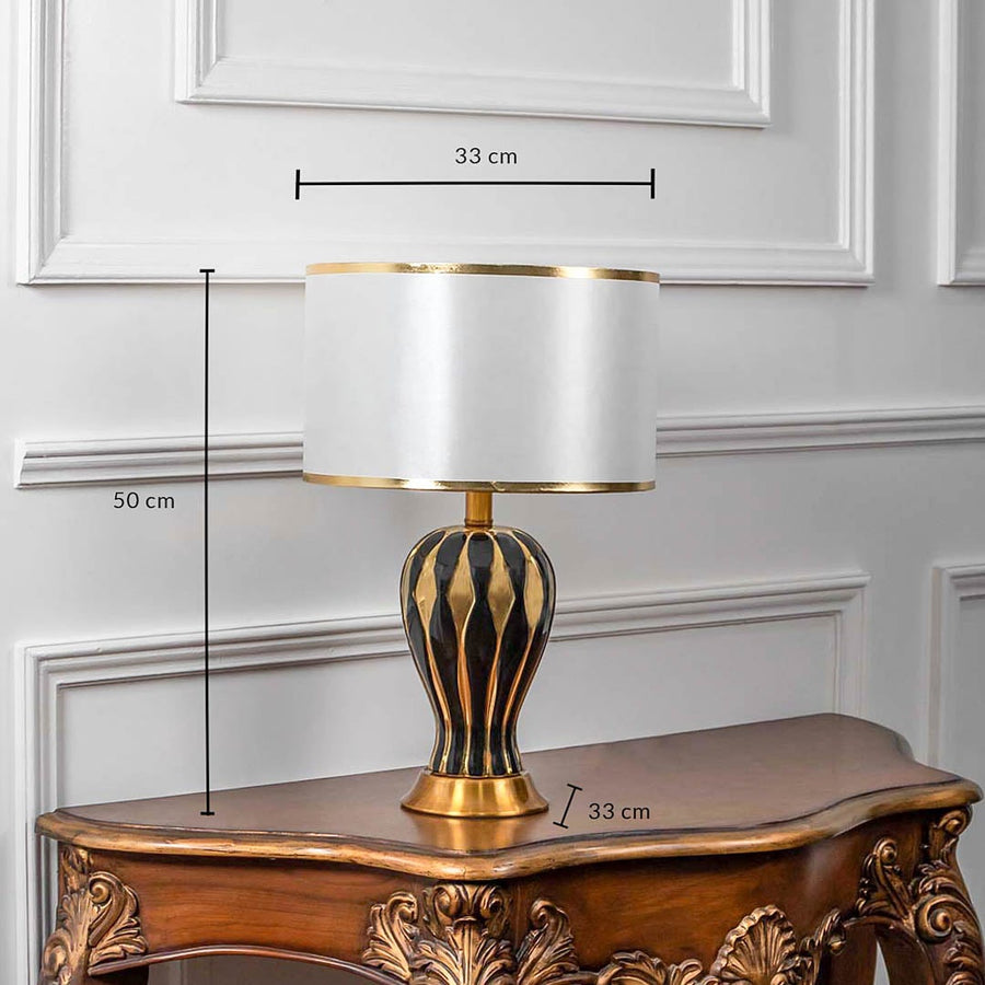 Black and gold striped table lamp with white shade shown with measurements 50 cm height and 33 cm width.