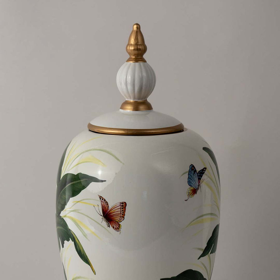 White ceramic jar with bird illustration and gold lid placed on white surface against neutral background enhancing artistic decorative home decor appeal.