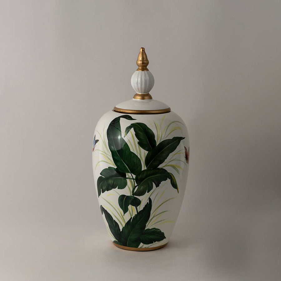 Elegant white ceramic decor jar with green tropical leaf artwork and gold detailing for stylish interior display.