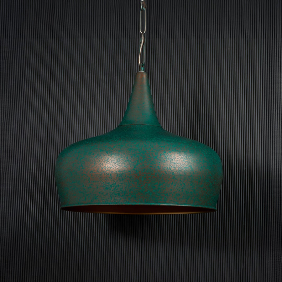 Green metal pendant light illuminated softly creating cozy ambiance in contemporary indoor spaces.