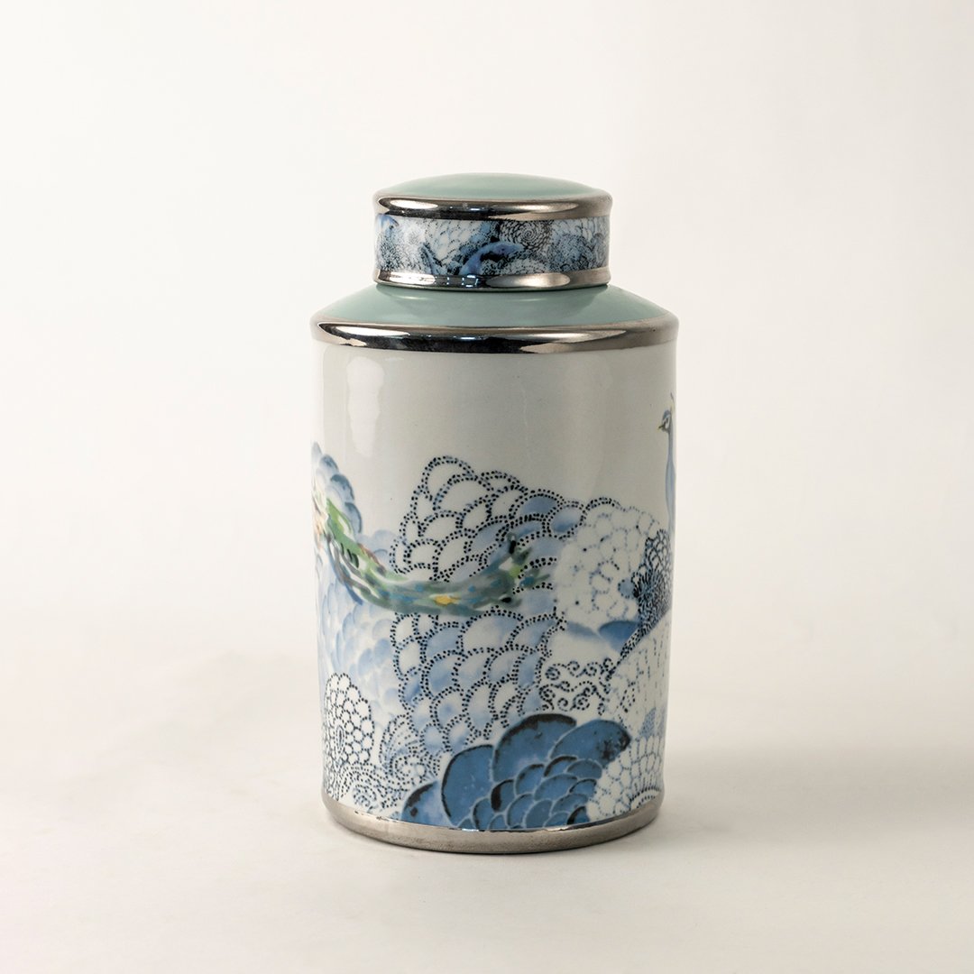 White ceramic decorative jar with blue wave pattern and silver lid for sophisticated tabletop styling and home decor.