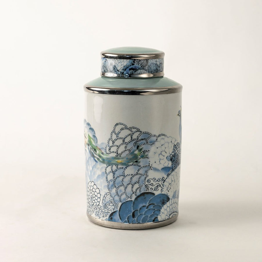 White ceramic decorative jar with blue wave pattern and silver lid for sophisticated tabletop styling and home decor.