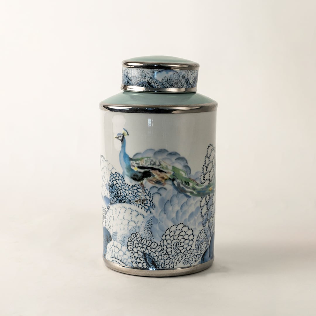 Blue and white ceramic jar with fish artwork shown on plain background for coastal inspired décor.