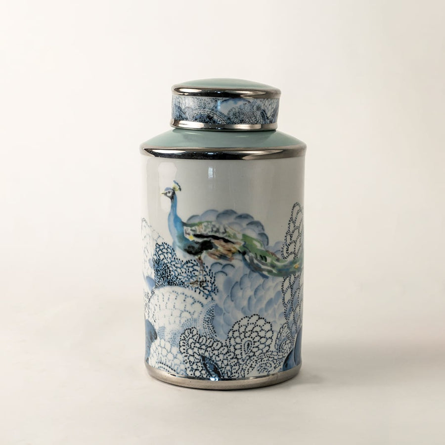 Blue and white ceramic jar with fish artwork shown on plain background for coastal inspired décor.