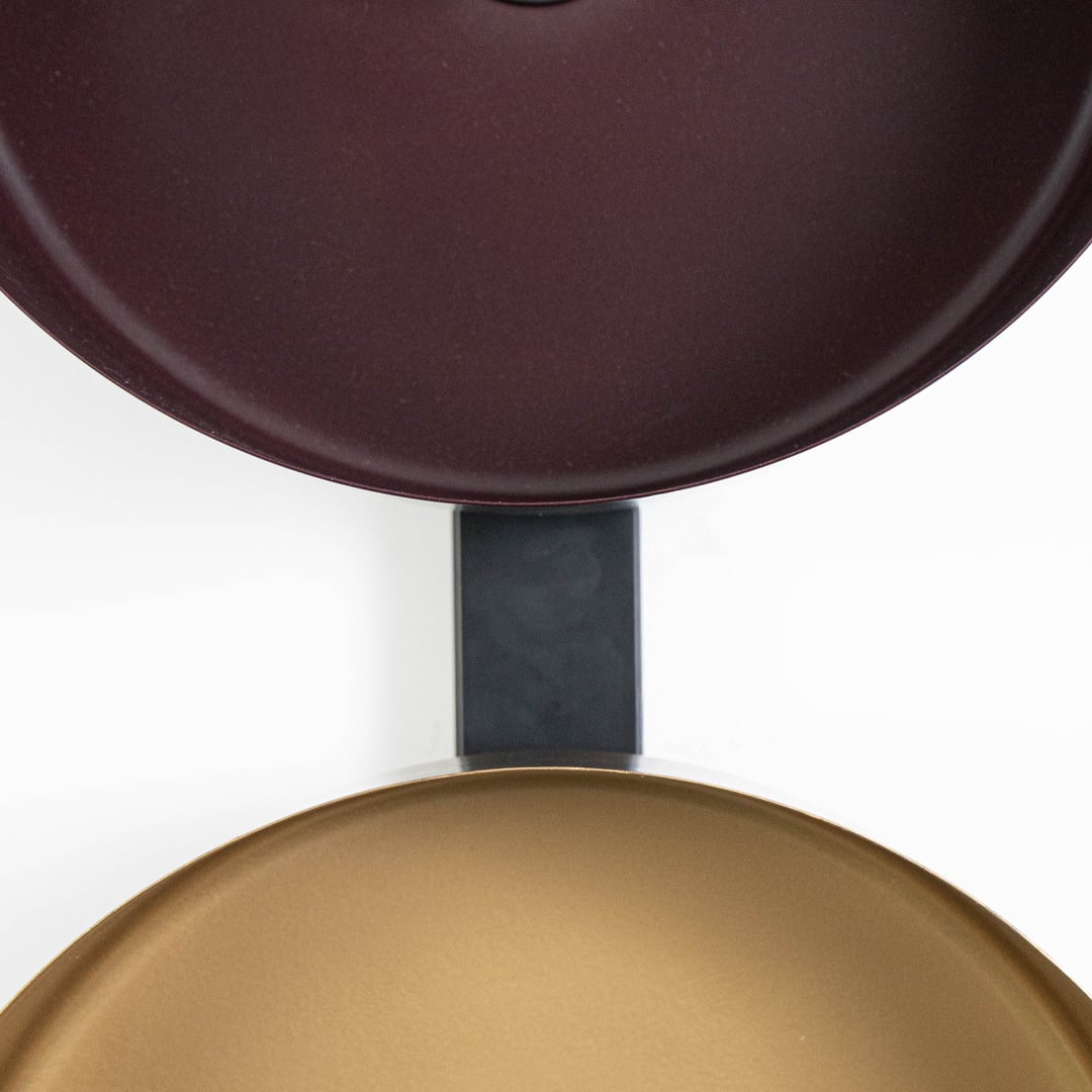 Top-down view of bronze and gold wall shades aligned on black frame showing texture and alignment detail.