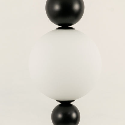 Closeup of white glass pendant light with black metal accents for elegant modern interior decor styling.