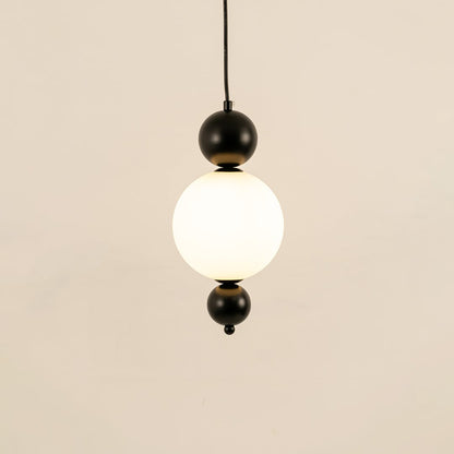 Black metal wall light with frosted glass globe illuminated to display contemporary decorative lighting elegance.