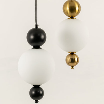 Black and gold metal wall lights with frosted glass globes illuminated to highlight modern lighting elegance.