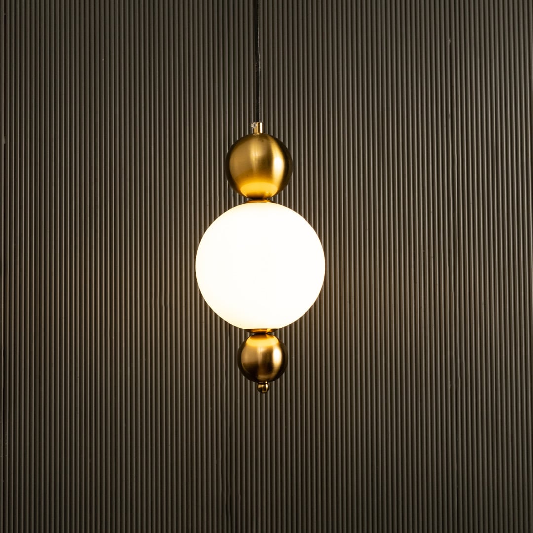 A contemporary white globe pendant with gold fittings ideal for LED suspension lighting and refined designer interior décor in modern living environments.