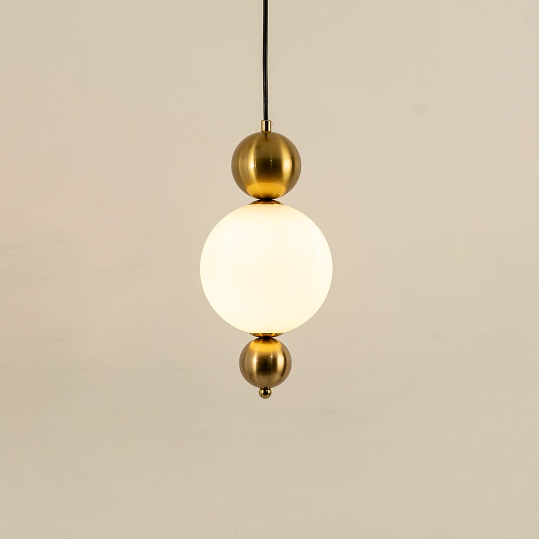 Gold metal wall light with frosted glass globe illuminated to showcase premium modern wall lighting design.