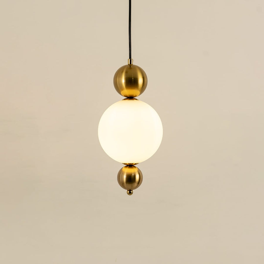 Gold metal wall light with frosted glass globe illuminated to showcase premium modern wall lighting design.