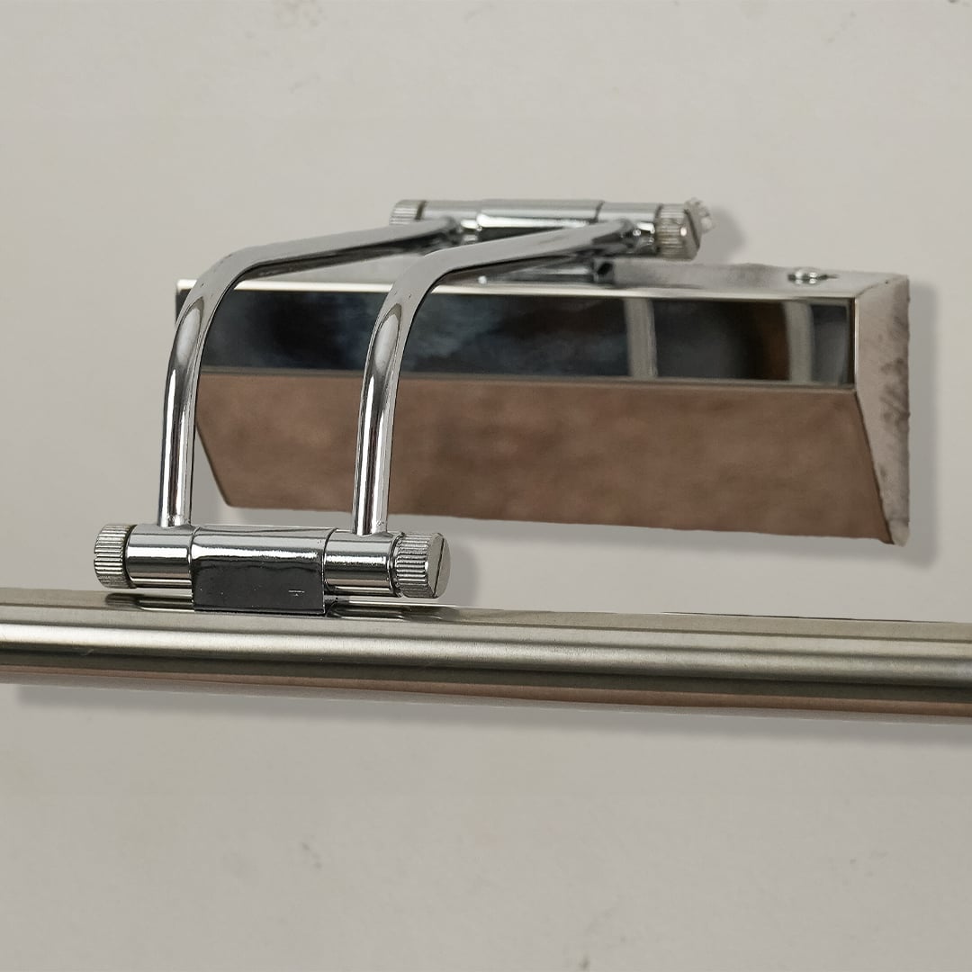 Closeup of chrome metal picture light showing polished finish slim bar design and warm directional illumination.