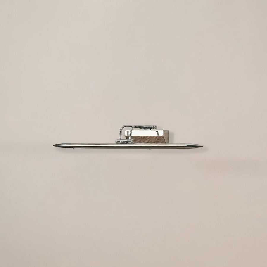 Chrome metal picture light on a white background with the light off highlighting its sleek modern reflective design.