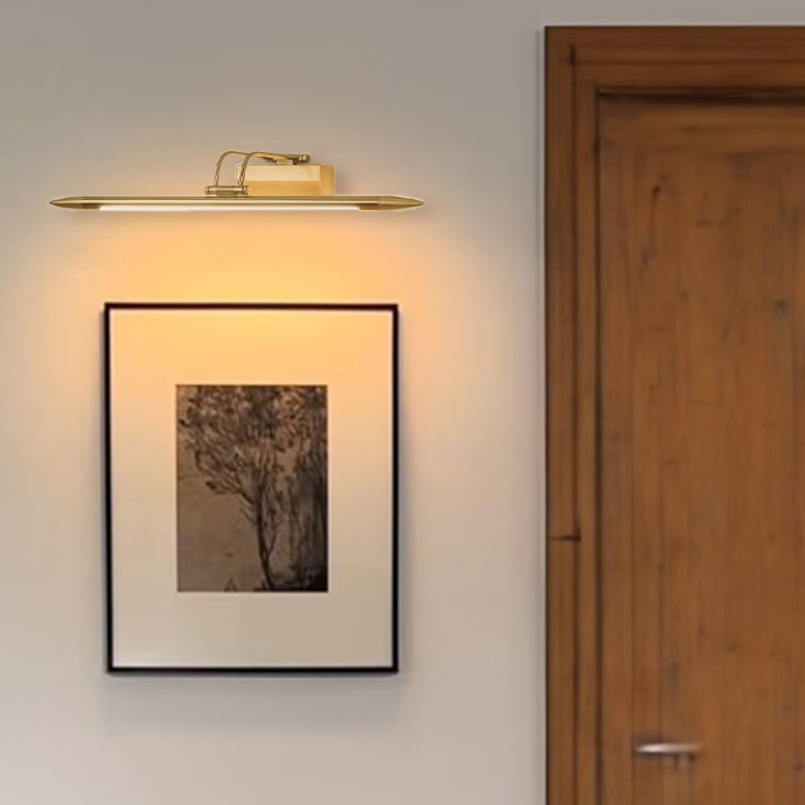 Lifestyle closeup of gold metal picture light enhancing artwork with warm focused directional illumination.