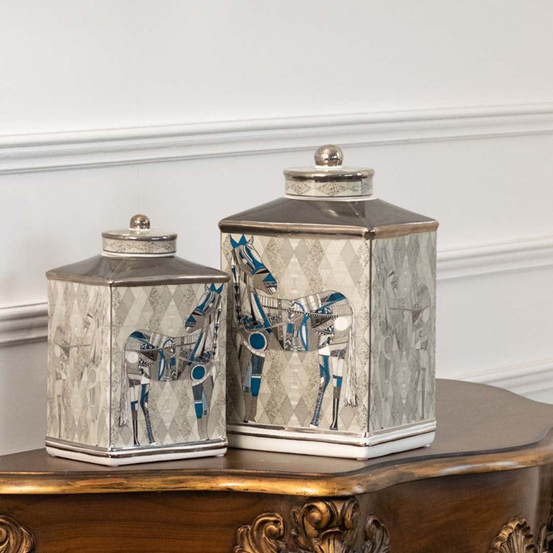 White jars with black abstract art placed on a wooden console table creating a modern artistic décor accent that enhances the interior space beautifully.