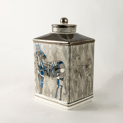 Grey ceramic decorative jar with blue floral artwork and silver lid for sophisticated shelf styling and home decor.