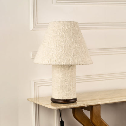 Natural stone table lamp with textured fabric shade bringing organic elegance to modern living room decor.