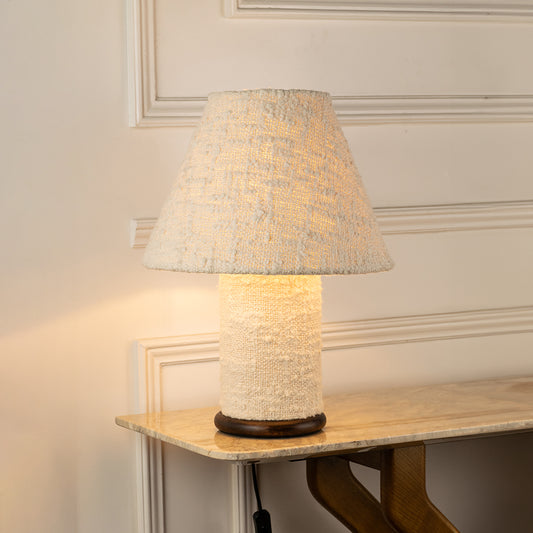 Table lamp with textured fabric shade and ceramic base perfect for cozy bedroom or living room table decor styling on clean background.