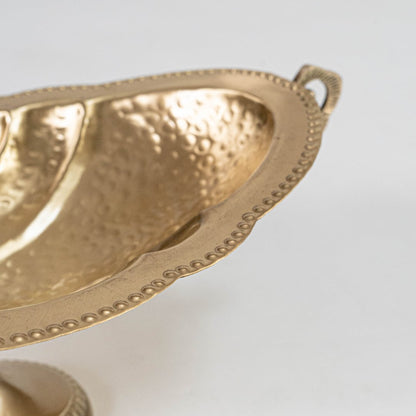 Gold fruit bowl with curved handles shown with 49 cm width 13 cm height and 17 cm depth on white background.
