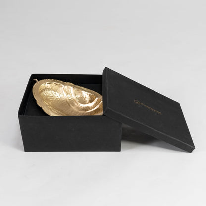 Front view of golden hammered metal fruit bowl with decorative twin handles and pedestal base on white background.