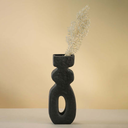 Modern black ceramic vase featuring geometric artistic form and matte textured finish for minimalist interiors.